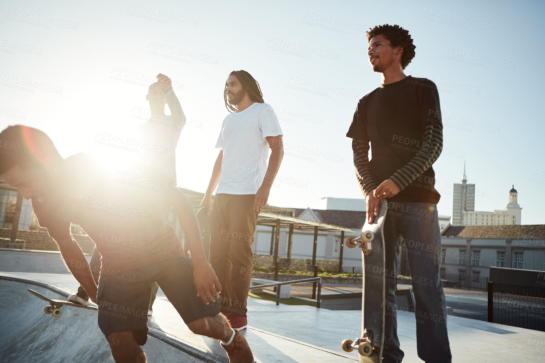 Buy stock photo Skateboard, hobby and friends in city for sport, competition challenge and start exercise by bowl. Outdoor, group and men at skate park for action, performance or ready to practice balance with flare