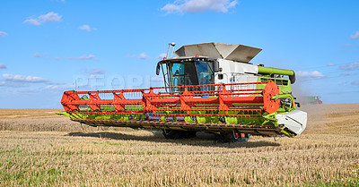 Buy stock photo Harvester, machine and crops on farm in nature for agriculture, cutting wheat and collection. Blue sky, vehicle and equipment for farming industry, food production and harvest season of plantation