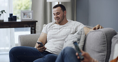Buy stock photo Man, relax and reading on sofa with phone, wife and smile for text message notification on weekend. Couple, happy person and browsing in home with tech, social media post and digital communication.