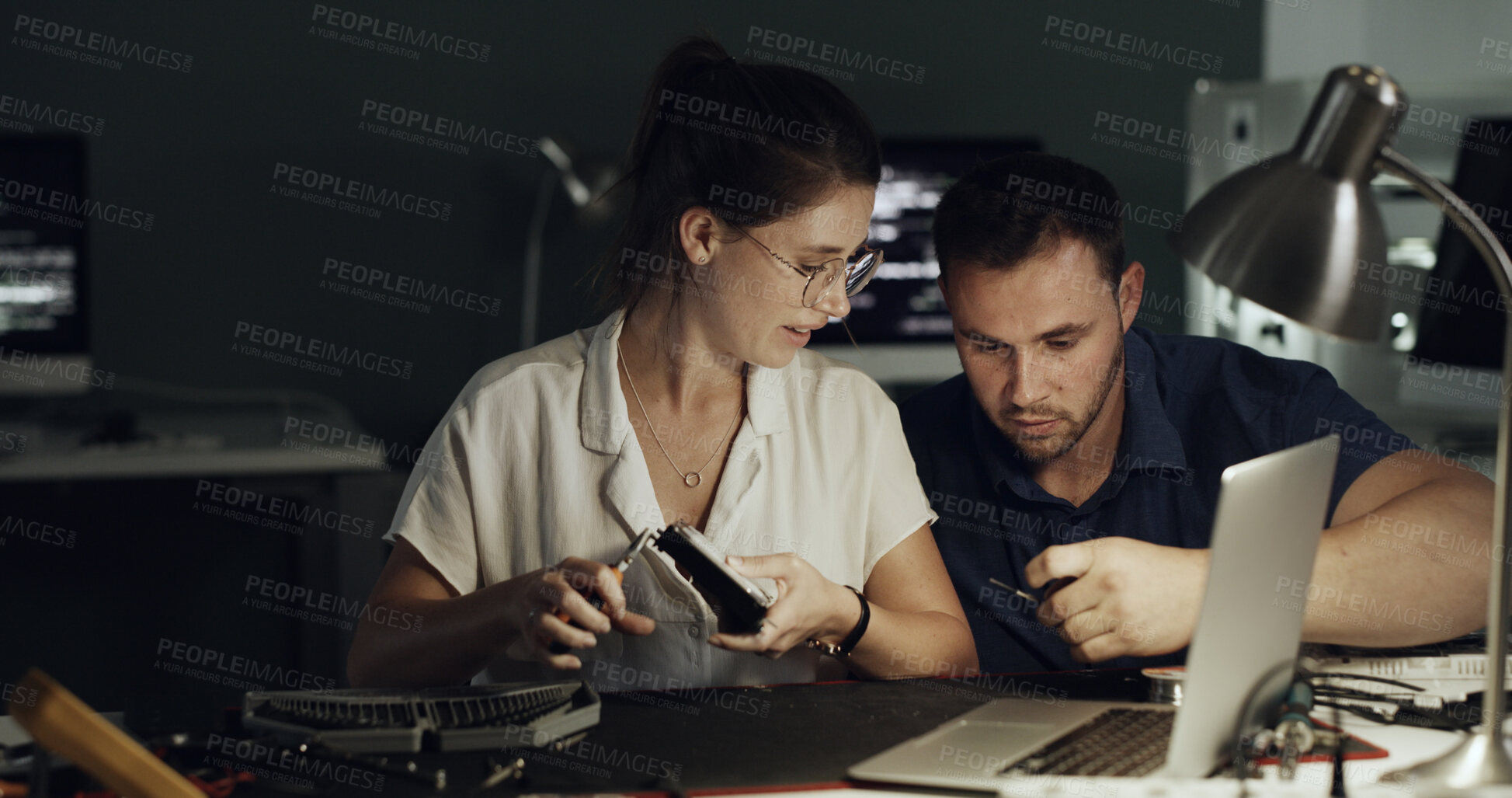 Buy stock photo Night, laptop and people with hardware for IT maintenance, repair and diagnostics for software. Technology, technician and team of workers with tools for troubleshooting, system test or programming