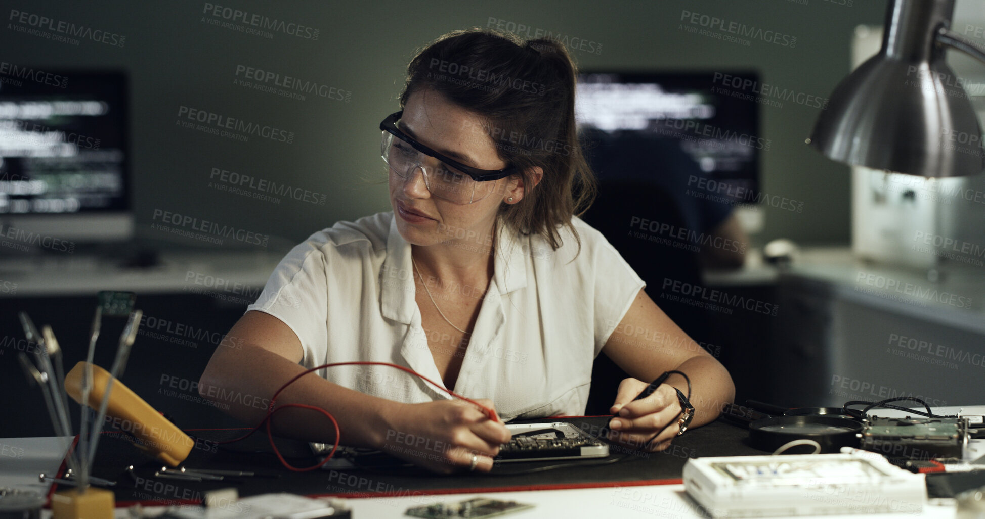 Buy stock photo Soldering, woman or motherboard repair in office for hardware diagnostics, continuity or safety. Night, technician and multimeter probe on circuit for PCB maintenance, signal tracing and electronics