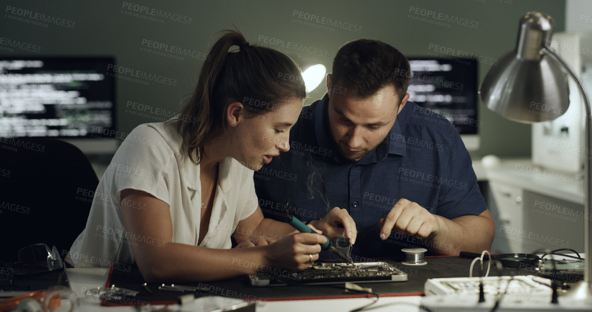 Buy stock photo Soldering, test or team in office with circuit board, repair or wiring guidance in hardware check. Electronics, people or engineers with tech, maintenance support or collaboration in system fix.