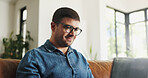 Freelancer, glasses and man with laptop, lounge and creative on couch, online and journalism in home. Typing, article and person with eyewear for project, remote work and happy with draft on website