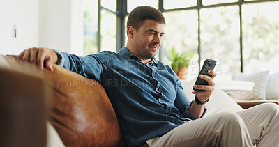 Buy stock photo Relax, phone and man on sofa in home for social media, reading news and online message on weekend. House, happy and person on smartphone for connection, communication and internet in living room