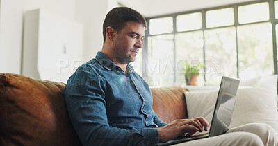 Buy stock photo Serious, freelancer and man with laptop, lounge and creative on couch, online and journalism in home. Typing, article and person with tech for project, remote work and draft on website or blog post