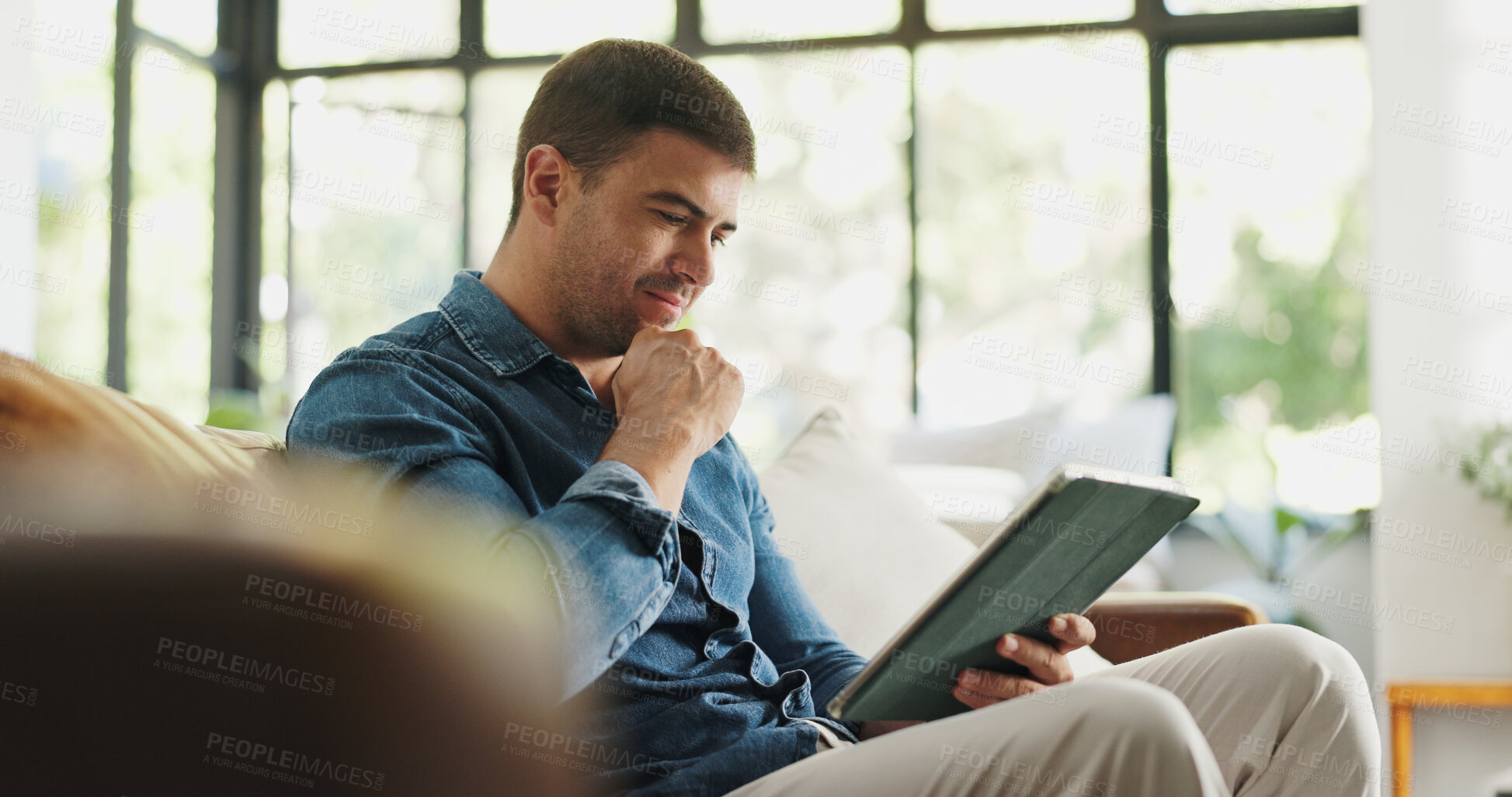 Buy stock photo Man, tablet and relax with thinking on sofa with movie choice, streaming or video in living room at house. Person, smile and tech with application, subscription and decision for film on couch at home