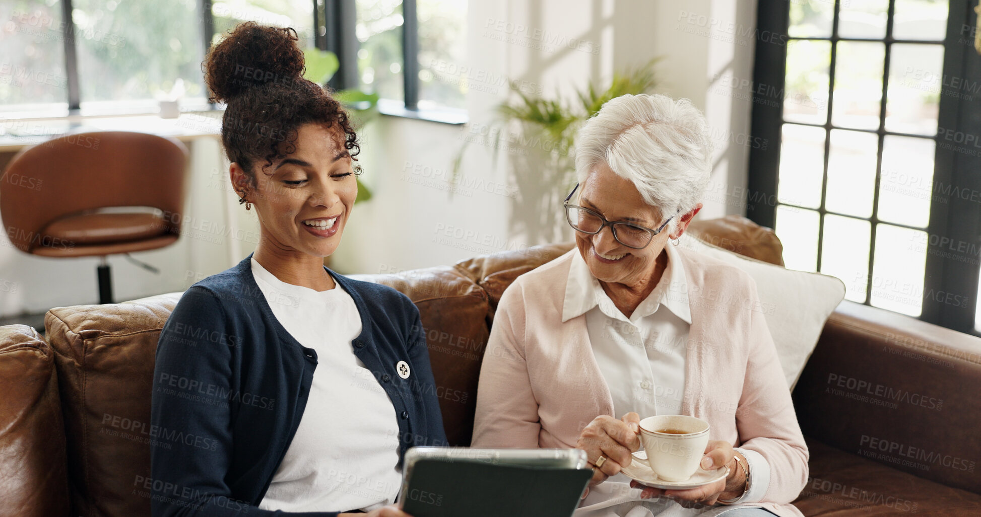 Buy stock photo Old woman, nurse and tablet on couch with tea for streaming, video or article in living room. People, caregiver and elderly person with tech, application and happy on sofa in retirement at house