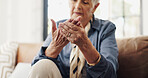 Hands, arthritis and injury in couch in home with fatigue, joint pain or carpal tunnel in lounge for retirement. Elderly woman, ache and fibromyalgia with inflammation on sofa in living room at house