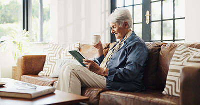 Buy stock photo Coffee, tablet or senior woman in home for reading news, relax or email in living room in retirement. Tea, technology and elderly person on sofa for online article, ebook or happiness on weekend