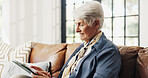 Old woman, tablet and relax on sofa with typing in home, smile and search for ebook in retirement. Elderly person, happy and tech on couch with application, scroll or streaming in lounge at house