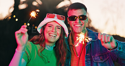 Buy stock photo Portrait, couple and smile with sparkler outdoor for fun, celebration and festival event. Happy, people and sunglasses with glow of fireworks, anniversary date and bonding together at new years party