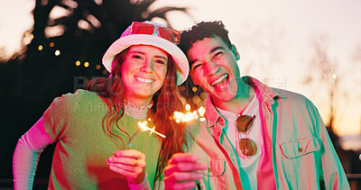 Buy stock photo Portrait, couple and happy with sparkler outdoor for fun, celebration and festival event. Excited, people and sunglasses with fireworks glow, social gathering and bonding together at new years party