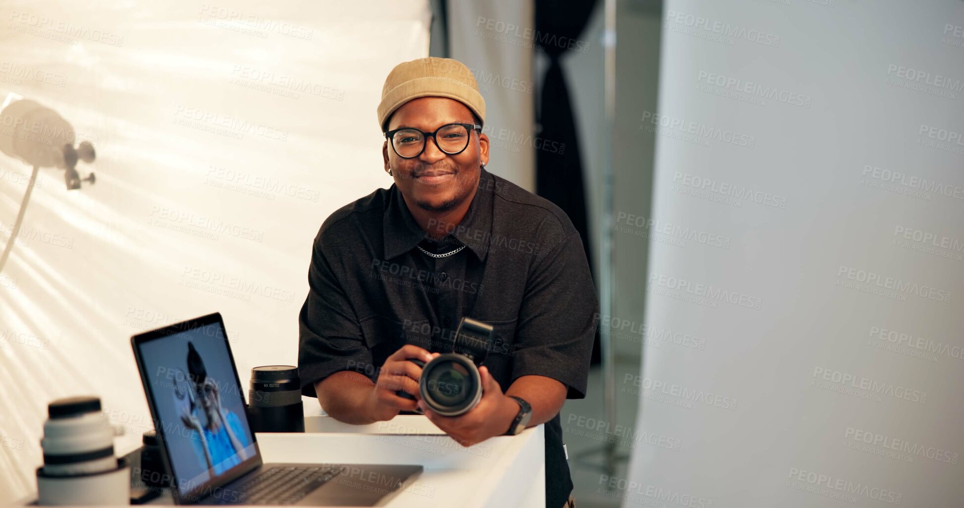 Buy stock photo Portrait, photographer and man in studio with camera, laptop and creative insight for media project. Space, black person and smile on set with photography equipment, computer and film production.