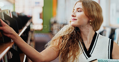 Buy stock photo Girl, student and smile with search at bookshelf in library with biology project for assessment at college. Woman, books and happy with choice, education and learning with scholarship at university