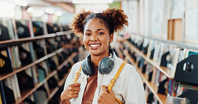 Buy stock photo Woman, university student and portrait with headphones in library for education, smile and bag at campus. Girl, happy and confidence for scholarship, learning and backpack for studying at college