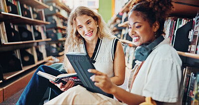 Buy stock photo Happy women, students and tablet with book in library for studying, online course or lesson. Female people, learners or reading with smile on technology for school project, knowledge or research