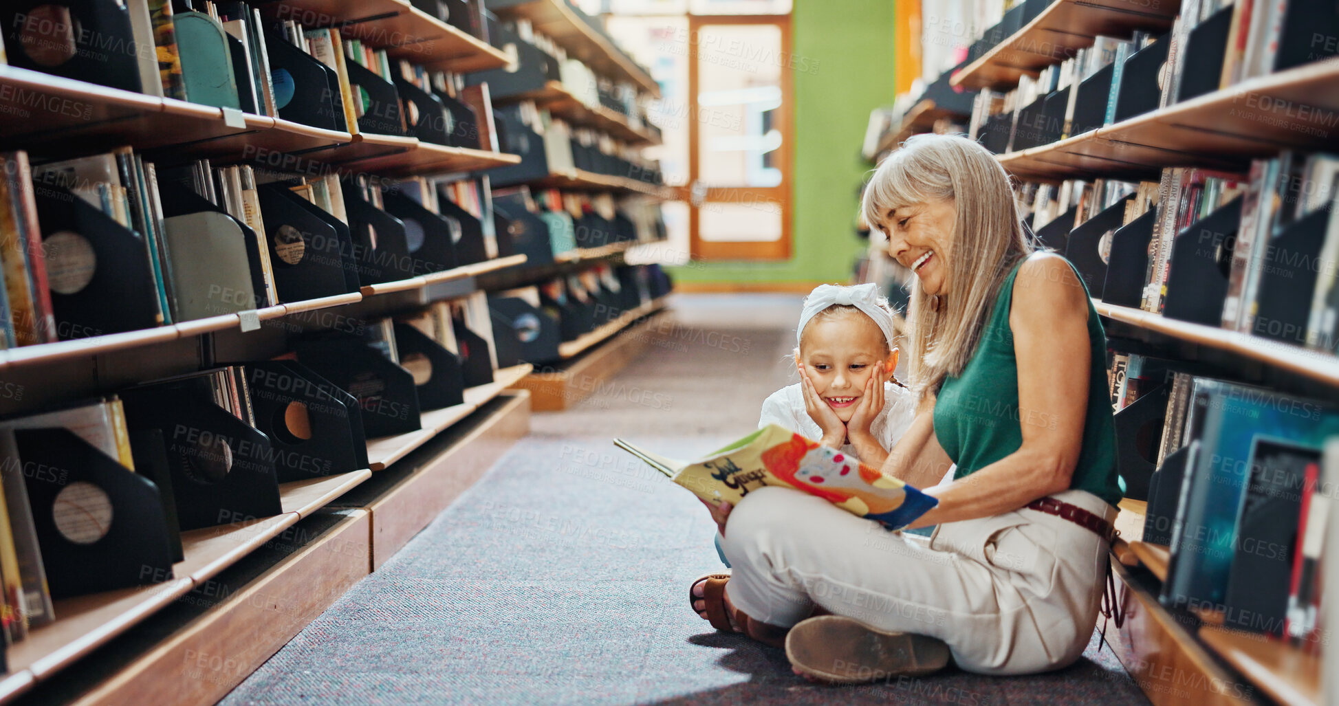 Buy stock photo Grandmother, reading book and girl in library, smile and bonding together for child development. Senior woman, kid or family on floor, happiness and support for education, literacy, hobby or teaching