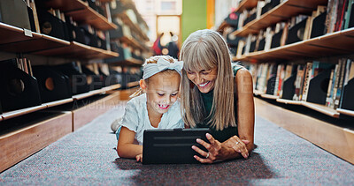 Buy stock photo Kid, tablet and grandmother in library with learning, reading ebook and literature for development. Happy, grandparent and girl with tech for online storytelling app, education and bonding together.