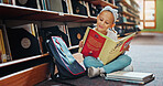 Reading, smile and child with book in library, language skills and vocabulary development for education. Literacy knowledge, fantasy story and girl with literature to learn,  academic growth and info