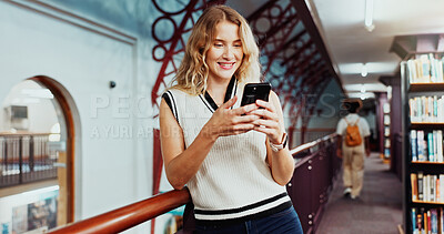 Buy stock photo Woman, university student and texting with phone at library for education, smile or contact at campus. Girl, smartphone and happy for web chat, mobile app and social media on study break at college