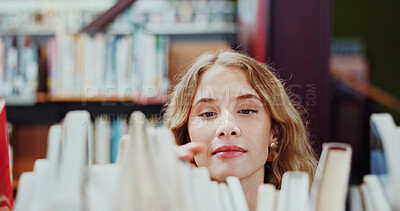 Buy stock photo Student, girl and search on bookshelf at college for book choice, pick textbook and knowledge. University, person and check course resources in library for study research, thesis citation or learning