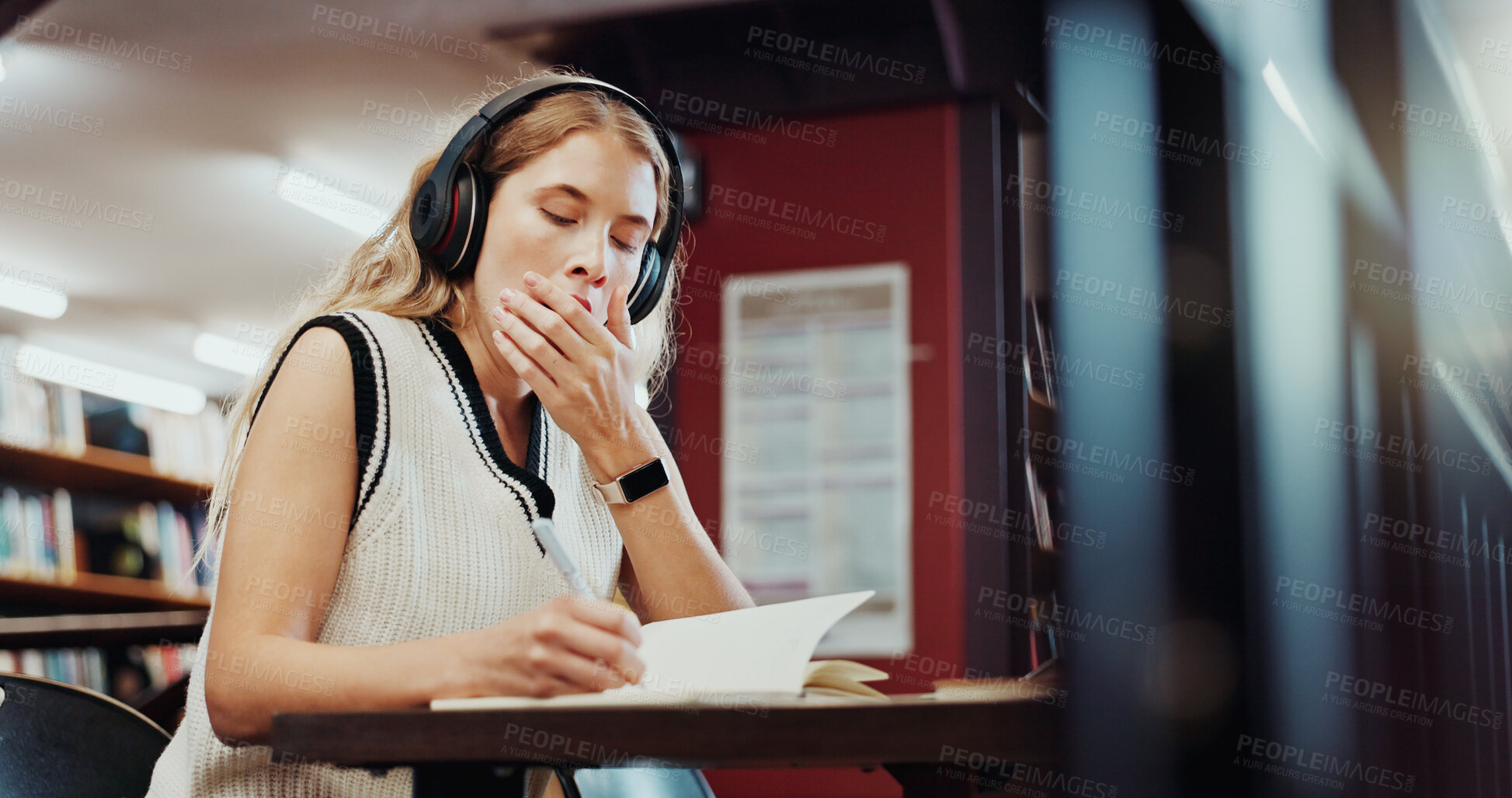 Buy stock photo Headphones, yawn or university student writing in library, study notes or streaming music for fatigue. Knowledge, tech or tired woman with notebook to learn, educational podcast or exam preparation