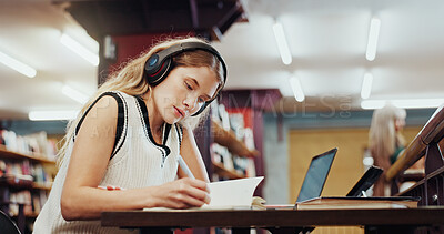 Buy stock photo College, woman and writing in library with headphones, study and music playlist for english assignment. Student, person and audio tech at university with literature notes, knowledge and online radio.