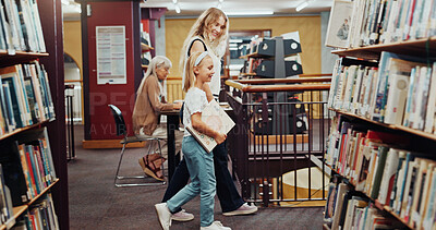 Buy stock photo Education, mother and walking with daughter in library for child development, literature or reading. Books, learning and student girl with woman parent in school for future, growth or study