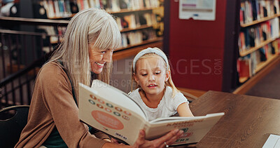 Buy stock photo Grandmother, reading book and girl in library, storytelling and bonding together for child development. Senior woman, kid or support for education, literacy and hobby with family and english language