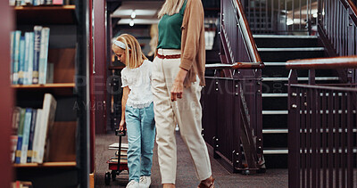 Buy stock photo Mother, girl and book cart in library, browsing novel selection and collect literature for knowledge. Walking, learning resources and woman with child in bookstore, parent support and study material