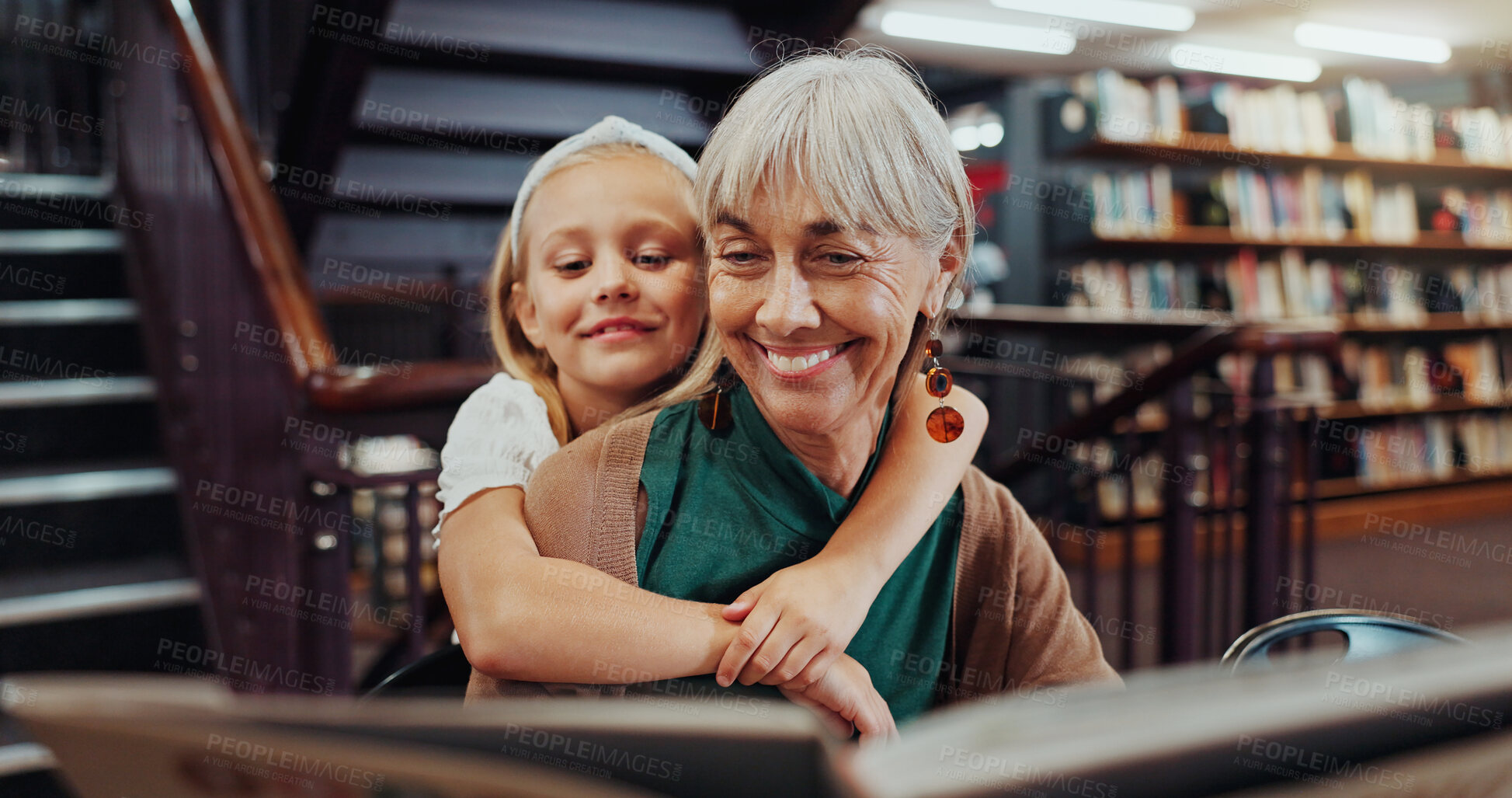 Buy stock photo Hug, library and reading with student and teacher on floor together for learning or literature. Book, development and education with happy girl child embracing mature woman for growth in school