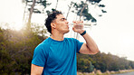 Man, fitness and drinking with water in nature for hydration, rest or workout recovery. Active, male person or runner with mineral liquid, aqua or beverage for break, exercise or outdoor training