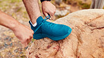 Shoelace, hands and man with fitness, hiking for health benefits and workout preparation in forest. Rock, hiker and person in woods, adventure and sneakers for trekking safety, exercise and wellness