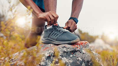 Buy stock photo Man, fitness and tie with sneakers on rock in nature for workout preparation or outdoor exercise. Active, male person or getting ready with hands for shoelaces training with hiking or trekking