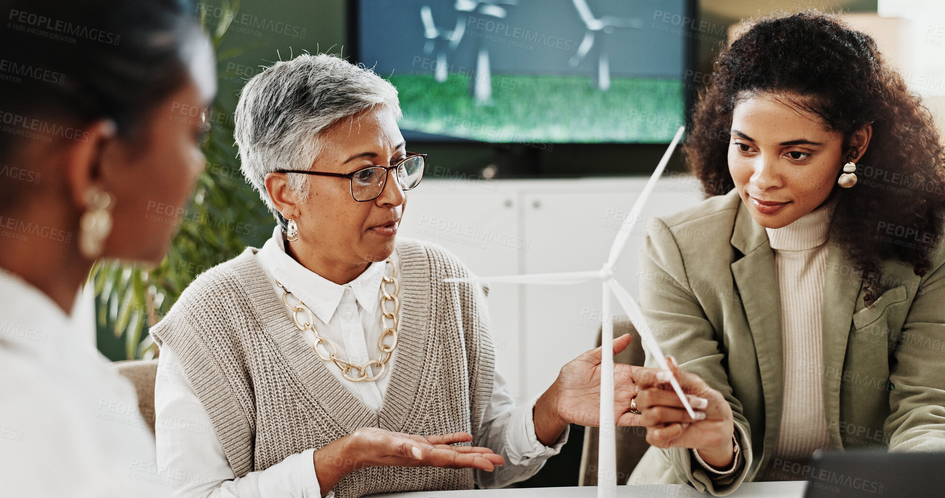 Buy stock photo Wind turbine, office and business women with discussion, eco friendly project or clean energy. Team, innovation or planning in company with windmill for sustainability, development or idea in meeting