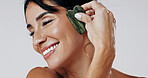 Woman, gua sha and happy with skincare in studio for circulation, massage and glow on white background. Mature person, stone tools and cosmetics with benefits, lymphatic drainage and dermatology