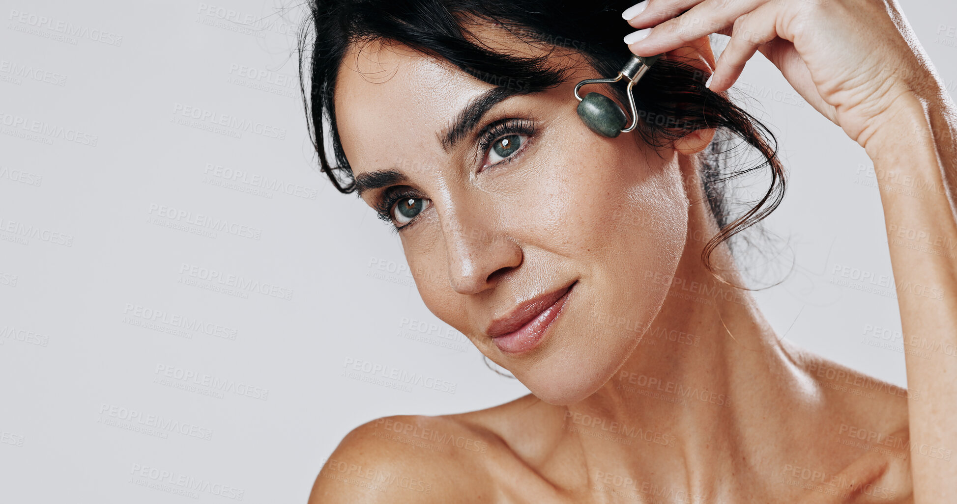 Buy stock photo Woman, beauty and skincare with jade roller in studio for lymphatic drainage on a white background. Female person, model or blood circulation with quartz tool for anti aging facial treatment on space