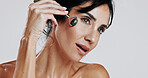 Woman, beauty and facial with jade roller in studio for anti aging on a white background. Female person, model or blood circulation with quartz tool for lymphatic drainage or skincare treatment