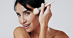 Woman, makeup brush and happy in studio portrait for beauty, powder and application on white background. Mature person, cosmetics and tools for facial foundation, blush and smile in New Zealand
