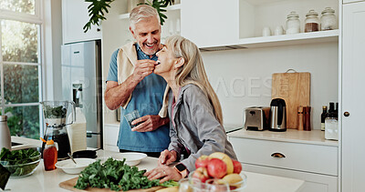 Buy stock photo Feed, fruit and old couple in kitchen with smoothie recipe, healthy diet and wellness for retirement. Married senior people, taste blueberry and bonding in home with breakfast, nutrition and support.