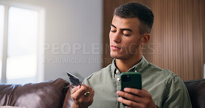 Buy stock photo Credit card, phone and man on sofa in home with online shopping, ecommerce or purchase on website. Technology, debit and male person with cellphone for paying bills with internet banking in house.