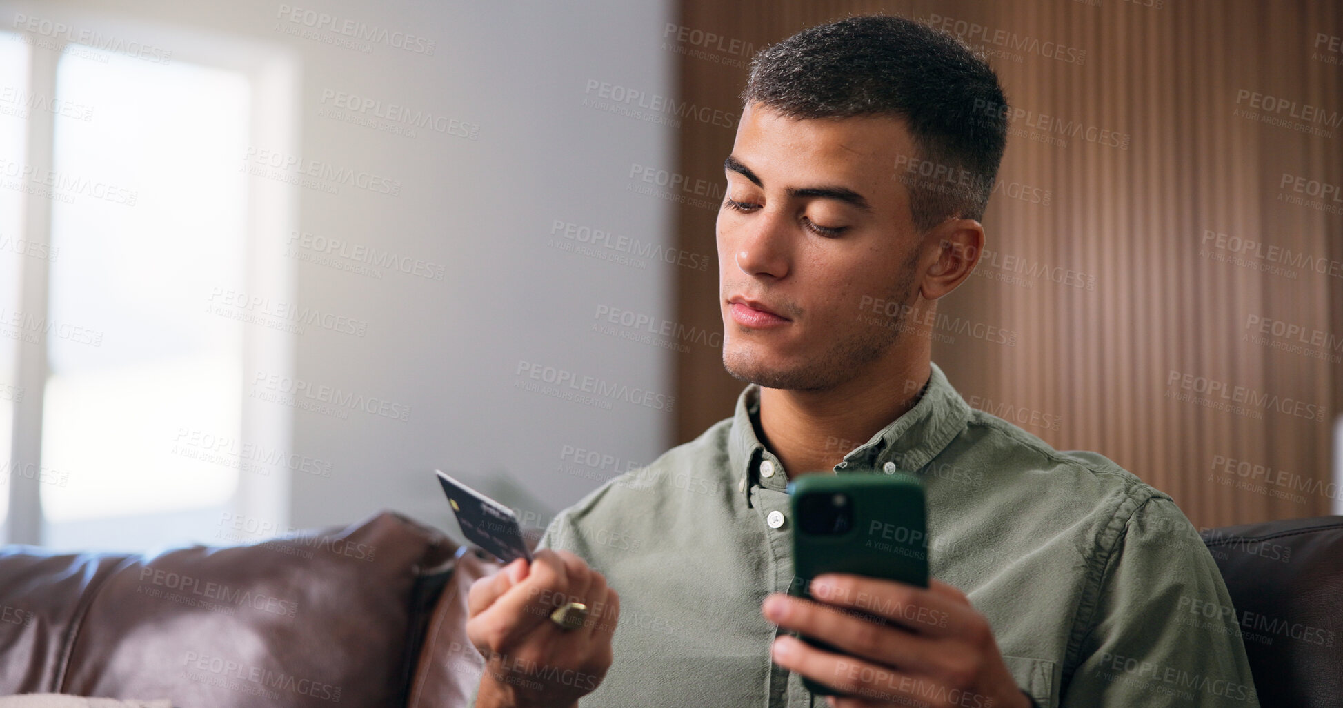 Buy stock photo Credit card, phone and man on sofa in home with online shopping, ecommerce or purchase on website. Technology, debit and male person with cellphone for paying bills with internet banking in house.