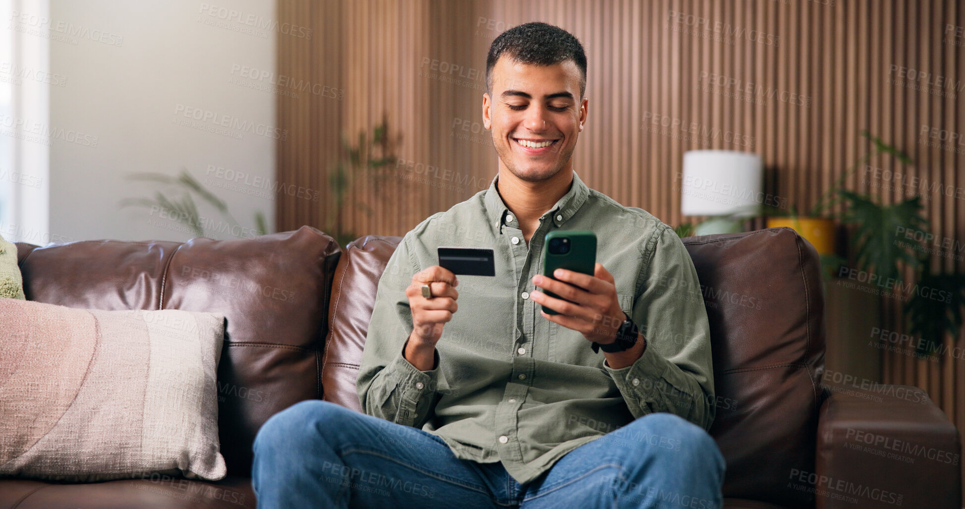 Buy stock photo Debit card, phone and man on sofa in home with online shopping, ecommerce or purchase on website. Technology, credit and male person with cellphone for paying bills with internet banking in house.