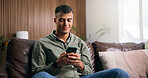 Happy, man and texting with smartphone on couch, home and communication with contact in living room. Reading, online and person with smile for message, relax and chat with mobile or typing in house