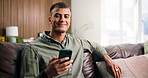 Man, phone and relax with smile on couch in home for texting, web chat or online dating in lounge. Person, smartphone and happy in portrait, contact or social network on sofa at apartment in Mexico