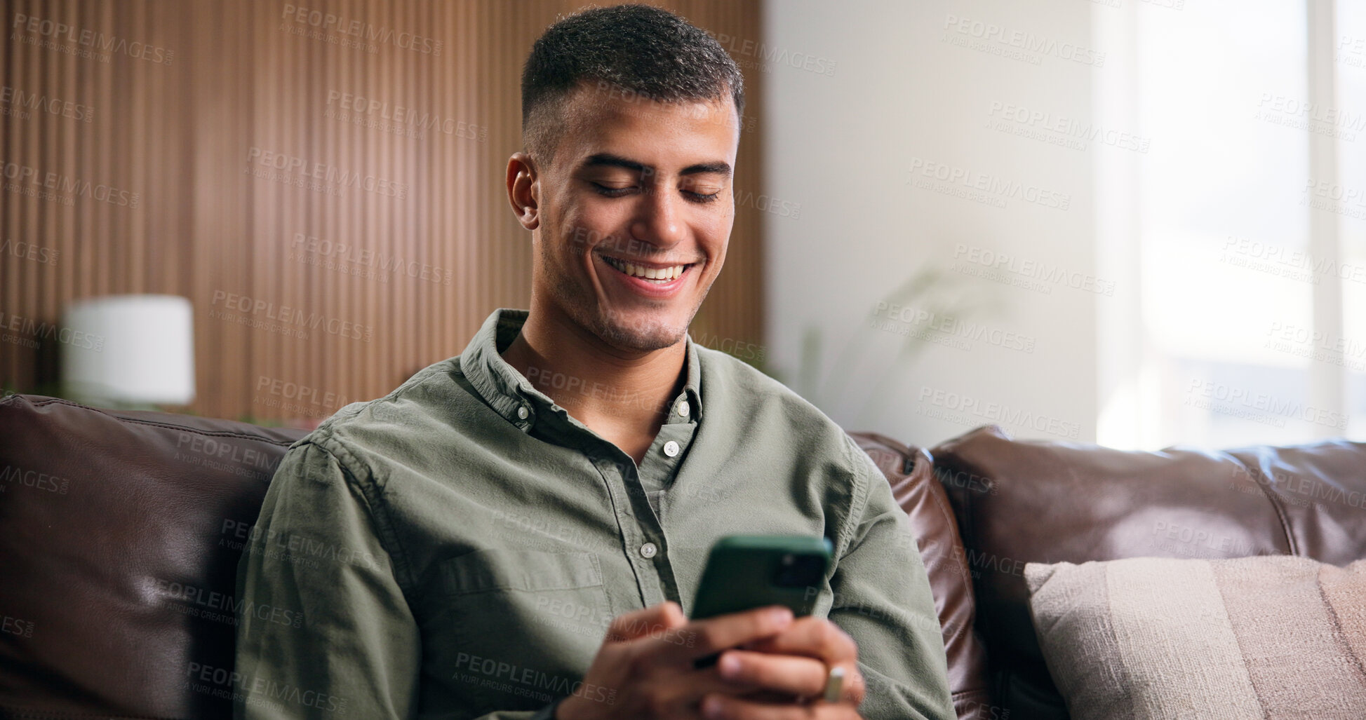 Buy stock photo Relax, happy and man on sofa with phone for social media, online message and chat in home. Weekend, house and person on smartphone for internet, connection and typing for notification on mobile app