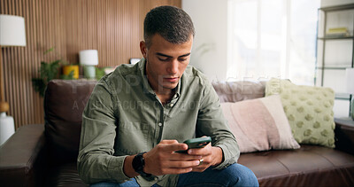 Buy stock photo Serious, reading and man with phone on sofa, browsing social media and check notification on message app. Watch video, mobile and person with sad news post in home, internet and online communication