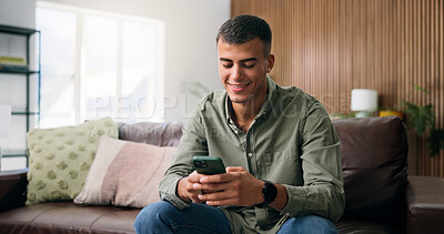 Buy stock photo Typing, happy and man on sofa with phone for social media, online dating and message in home. Weekend, house and person on smartphone for internet, connection and chat for notification on mobile app