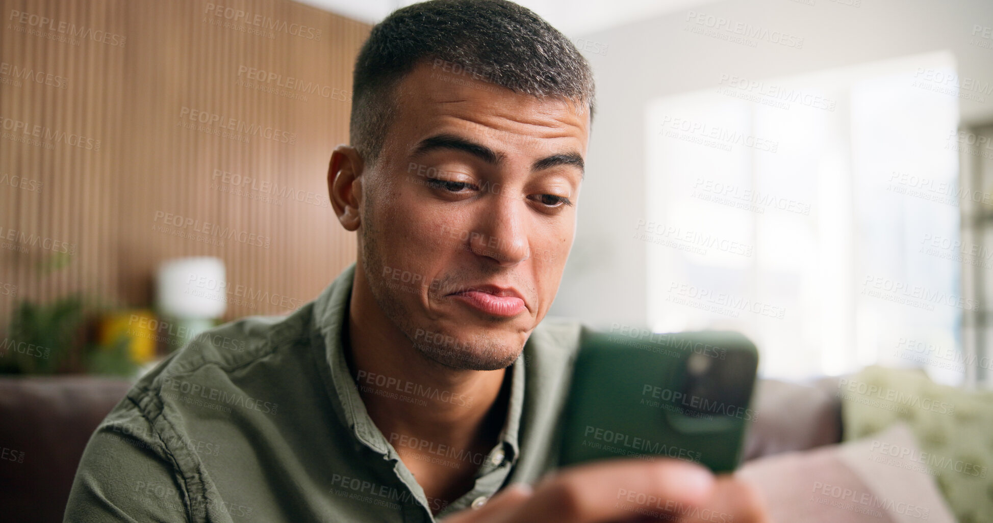 Buy stock photo Typing, doubt and man on sofa with phone for social media, online dating and contact in home. Weekend, unsure and person on smartphone for internet, notification and reading odd message on mobile app