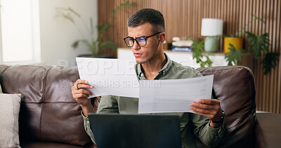 Buy stock photo Man, reading and documents with laptop in home for finanial planning, audit or investment on sofa. Male person, checking and paperwork with insurance on computer for budget, finance bills or expenses